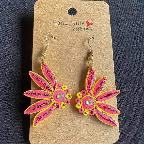 Pink and yellow floral earrings on a 'Handmade with Love' card against a dark background