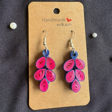 Pair of pink and blue quilled earrings on a 'Handmade with Love' card against a dark background.