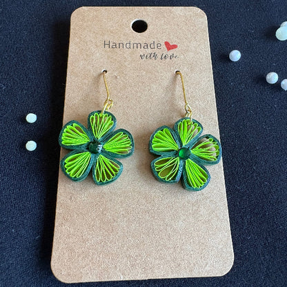 Green flower-shaped earrings on a 'Handmade with Love' card against a dark background.