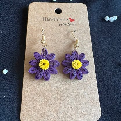 Purple flower earrings on a 'Handmade with Love' card against a dark background